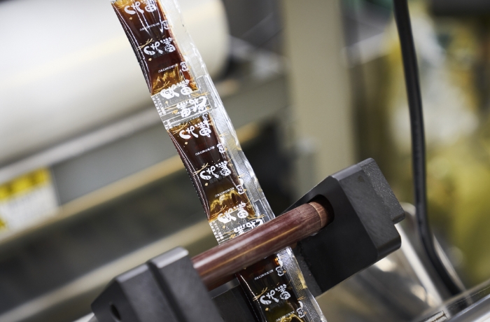 ソース・たれ・ドレッシングなど液体調味料を小袋・ポーションカップ・スタンドパウチへ充填する様子